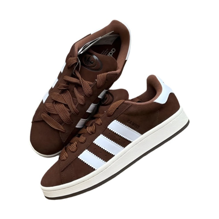 Brown Adidas sneakers with white stripes on a white background