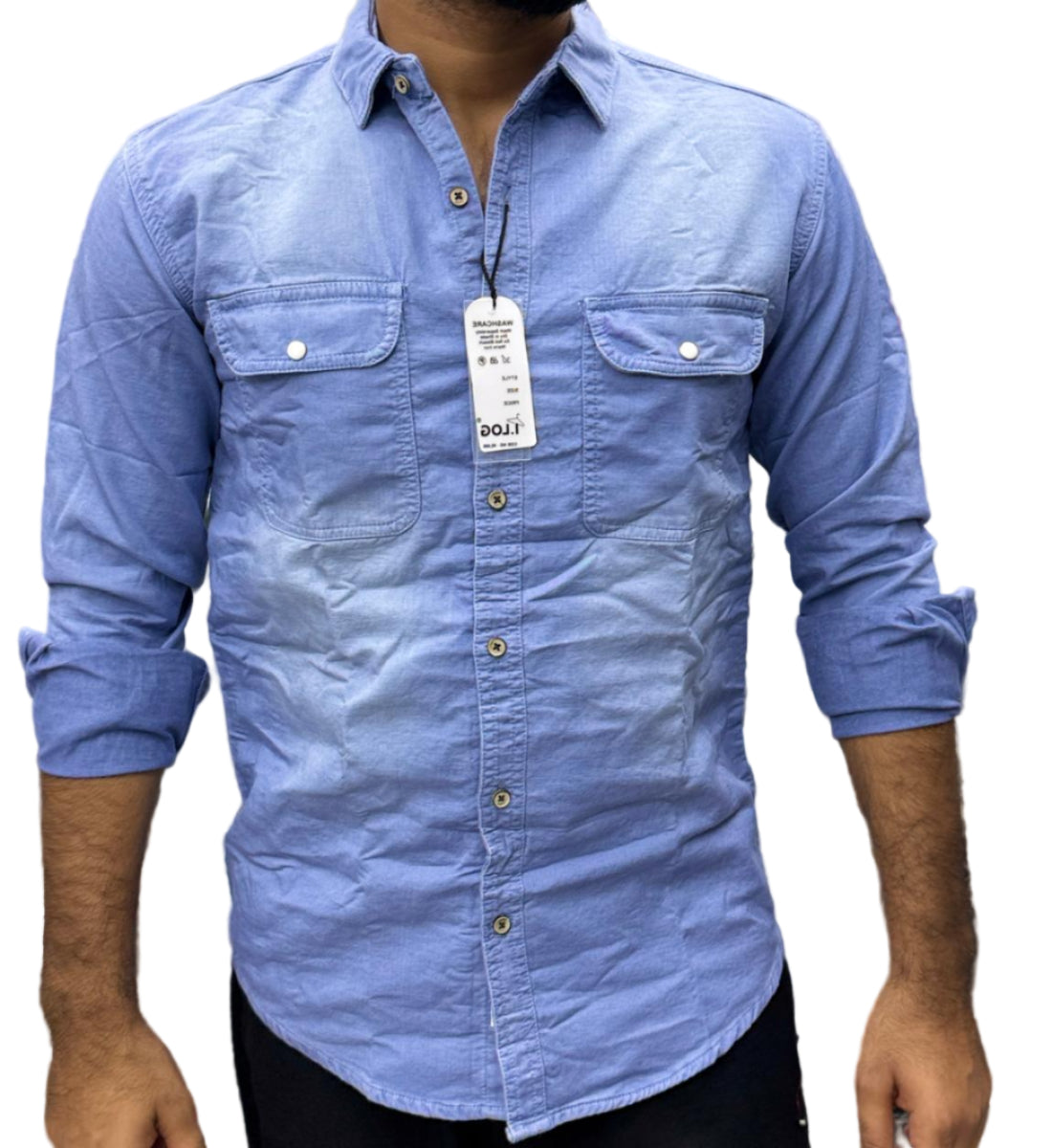 Blue shirt with a tag worn by a person, against a blurred background